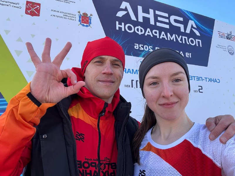 Два участника у стенда полумарафона «Арена».